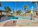 Resort-style backyard with a sparkling pool, spa, lush landscaping, and shaded seating areas at 6938 W Wescott Dr, Glendale, AZ 85308
