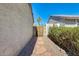 Charming side yard featuring a stone walkway, desert landscaping, a wooden gate, and lush greenery at 6938 W Wescott Dr, Glendale, AZ 85308