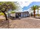 Back exterior view with covered patio and easy-care gravel yard with decorative palm tree at 7302 E Baseline Rd, Mesa, AZ 85209