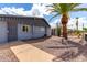Inviting exterior with gravel landscaping, palm tree, and pathway to the home's entrance at 7302 E Baseline Rd, Mesa, AZ 85209