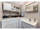 Functional laundry area features a washer and dryer, storage shelves, and a convenient sink with vanity at 7302 E Baseline Rd, Mesa, AZ 85209