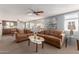 Bright living room featuring comfortable seating, ceiling fan, and ample natural light from large windows at 7302 E Baseline Rd, Mesa, AZ 85209