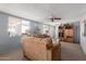 Bright living room with comfortable couches, ample natural light, and a classic ceiling fan for year-round comfort at 7302 E Baseline Rd, Mesa, AZ 85209