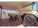 Outdoor covered patio with dining and barbecue area, featuring a table, four chairs, and a grill at 7302 E Baseline Rd, Mesa, AZ 85209