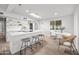 Bright, modern kitchen with white cabinets, a skylight, a breakfast bar with seating and wood floors at 7802 E Kimsey Ln, Scottsdale, AZ 85257
