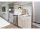 Kitchenette with stainless steel appliances, open shelving, and white subway tile backsplash at 7802 E Kimsey Ln, Scottsdale, AZ 85257