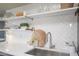 Kitchenette featuring open shelving, a stainless steel sink, and a white subway tile backsplash at 7802 E Kimsey Ln, Scottsdale, AZ 85257