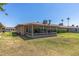 View of backyard with enclosed patio and green lawn in well maintained condition at 10449 W Tropicana Cir, Sun City, AZ 85351