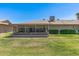 View of backyard with enclosed patio and green lawn in well maintained condition at 10449 W Tropicana Cir, Sun City, AZ 85351