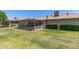 View of backyard with enclosed patio and green lawn in well maintained condition at 10449 W Tropicana Cir, Sun City, AZ 85351