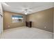Bedroom features a ceiling fan, carpet floors, and bright window at 10449 W Tropicana Cir, Sun City, AZ 85351