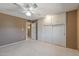Carpeted bedroom with ceiling fan, storage, and built-in cabinets at 10449 W Tropicana Cir, Sun City, AZ 85351