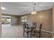 Inviting dining area with a glass-top table, chandelier, and seamless flow to an adjacent living space at 10449 W Tropicana Cir, Sun City, AZ 85351