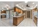 Open kitchen featuring tile flooring, wooden cabinets, and a breakfast bar with views to the outdoors at 10449 W Tropicana Cir, Sun City, AZ 85351