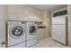 Convenient laundry room with ample storage space and a modern washer and dryer at 10449 W Tropicana Cir, Sun City, AZ 85351