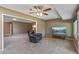 Spacious living room with a recliner, TV, and seamless connection to another living area at 10449 W Tropicana Cir, Sun City, AZ 85351