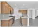 Modern kitchen with stainless steel appliances, gray tile floors, quartz countertops and wooden cabinets at 10912 E Tiburon Ave, Mesa, AZ 85212