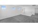 Open loft area with gray carpet, white walls, and ample natural light from several windows at 10912 E Tiburon Ave, Mesa, AZ 85212