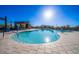 Beautiful community pool surrounded by light colored pavers and blue skies overhead at 10912 E Tiburon Ave, Mesa, AZ 85212