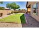 The spacious backyard features a grassy lawn, mature landscaping, and a covered patio at 11664 W Eagle Ct, Surprise, AZ 85378
