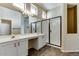 Bathroom featuring a double vanity, a large mirror, a walk-in shower, and tiled flooring at 11664 W Eagle Ct, Surprise, AZ 85378