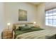 Digitally staged bedroom with wood floors, a large window, and a minimalist style at 11664 W Eagle Ct, Surprise, AZ 85378