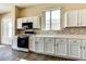 Bright kitchen with white cabinets, modern appliances, and tiled backsplash at 11664 W Eagle Ct, Surprise, AZ 85378