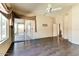 Spacious living room featuring dark wood flooring, a ceiling fan, and a large sliding glass door to a patio at 11664 W Eagle Ct, Surprise, AZ 85378