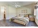 Digitally staged main bedroom with wooden floors, ceiling fan, and a view of an arched doorway at 11664 W Eagle Ct, Surprise, AZ 85378