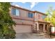 Inviting two-story home showcasing desert landscaping, a two-car garage, and covered front porch at 1222 E Canyon Trl, San Tan Valley, AZ 85143