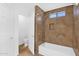 Elegant bathroom featuring stone-tiled walk-in shower and bathtub at 1308 E Rosemonte Dr, Phoenix, AZ 85024