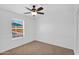 Bright, carpeted bedroom featuring a ceiling fan and a window overlooking the side yard at 1308 E Rosemonte Dr, Phoenix, AZ 85024