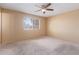 Cozy bedroom featuring plush carpeting, a ceiling fan, and a sunlit window at 1348 W Rockwood Dr, Phoenix, AZ 85027