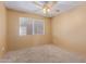 This bedroom has neutral carpet, a window and a ceiling fan at 1348 W Rockwood Dr, Phoenix, AZ 85027