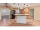 Open kitchen with custom wood cabinetry, an island with cooktop, and stainless hood vent at 1348 W Rockwood Dr, Phoenix, AZ 85027