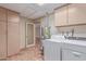 Functional laundry room features tile flooring, a washer and dryer, and built-in storage at 1348 W Rockwood Dr, Phoenix, AZ 85027