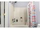Bathroom featuring a white tiled bathtub with colorful polka-dot patterned curtain at 16036 N 11Th Ave # 1086, Phoenix, AZ 85023