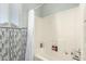 Bright tub and shower combination with white tile and modern decorative accent wall at 16036 N 11Th Ave # 1086, Phoenix, AZ 85023