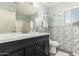Bathroom featuring modern vanity, large mirror, decorative tile accent wall, and a shower-tub combo at 16036 N 11Th Ave # 1086, Phoenix, AZ 85023
