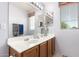 Bathroom featuring dual sinks, wood cabinets, vanity mirrors, and natural lighting at 16036 N 11Th Ave # 1086, Phoenix, AZ 85023