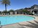 Inviting community pool area with lounge chairs, palm trees, and clear blue water at 1718 S 82Nd Way, Mesa, AZ 85209