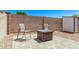Landscaped backyard featuring a tiled patio, a fire pit, chairs and a storage shed at 18555 N 114Th Ave, Surprise, AZ 85378