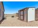 Private backyard featuring a shed, patio with a fire pit and chair, and decorative lighting at 18555 N 114Th Ave, Surprise, AZ 85378