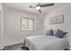 A bright bedroom with wood-look floors, window, ceiling fan and minimalist decor at 18555 N 114Th Ave, Surprise, AZ 85378