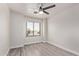 Minimalist bedroom features wood floors, ceiling fan, and window at 18555 N 114Th Ave, Surprise, AZ 85378