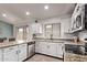 Well-lit kitchen with granite counters, stainless steel appliances, white cabinets, and tile floors at 18555 N 114Th Ave, Surprise, AZ 85378