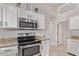 Kitchen features stainless steel oven, microwave and granite counters, complemented by white cabinets at 18555 N 114Th Ave, Surprise, AZ 85378