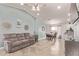 Open-concept living room with tile floors, ceiling fan, and ample natural light at 18555 N 114Th Ave, Surprise, AZ 85378