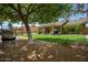 A spacious backyard with manicured lawn, pergola-covered patio, and mature trees, ideal for outdoor living at 18823 N 97Th Ln, Peoria, AZ 85382