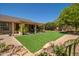 Large backyard with a pergola-covered patio, green lawn, and mature landscaping, perfect for entertaining at 18823 N 97Th Ln, Peoria, AZ 85382